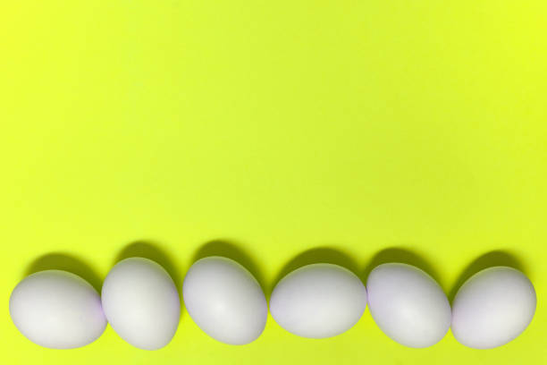 istock Row of white easter eggs on yellow background, copy space. Healthy food concept. Top view, flat lay. Happy Easter concept 1298616475