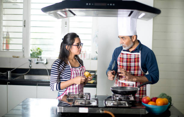 istock Father giving culinary lessons to daughter at kitchen 1298617229