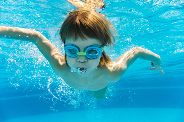 istock Little boy enjoying to dive in swimming pool 1298617574