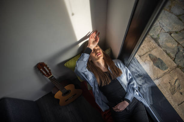 Guitar lessons at home, focused person on fretboard practice, learning instrument basics of rock and country.