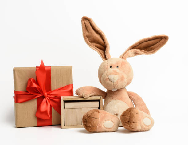istock cute plush rabbit and a box with a gift tied with a red silk ribbon 1298619919