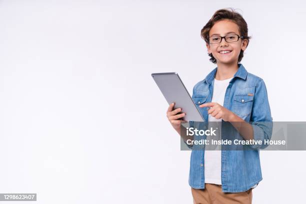 Smart Young White Boy Using Tablet In Casual Outfit Isolated Over White Background Stock Photo - Download Image Now