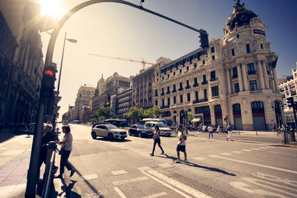 2019 09, Madrid, Spain. Madrid street, vintage style and sun flares. Pedestrian crossing and traffic lights on Alcala Street in back light. People crossing an avenue in Madrid Spain at traffic lights. View of the city streets. iron cross stock pictures, royalty-free photos & images