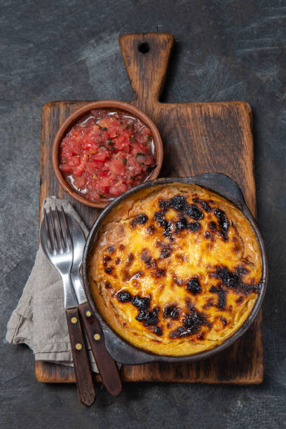 istock Chilean food. Traditional Pastel de Choclo corn pie. Beef meat with onion, chicken and egg covered with ground corn in clay bowl, top view 1298624607
