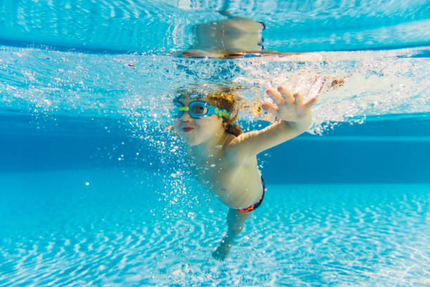 istock Little boy having fun diving underwater 1298627725