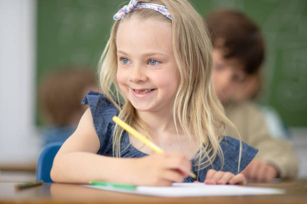 istock Smiling school girl in class 1298627834