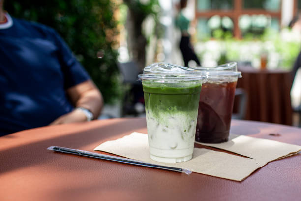 Green Matcha Latte and coffee Green Matcha Latte and coffee in plastic cup on table in the cafe garden. heathy stock pictures, royalty-free photos & images