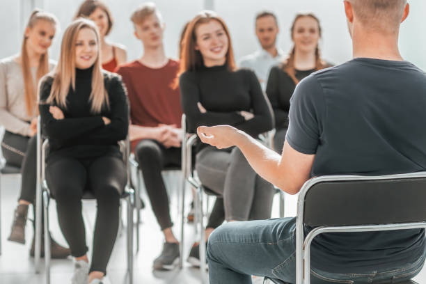istock speaker and a group of young people sitting in a conference room 1298628676