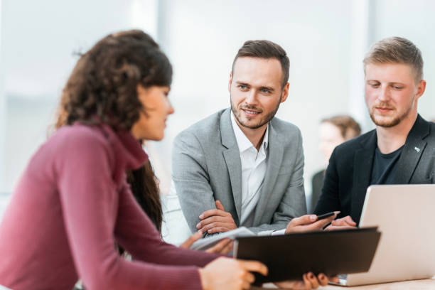 istock young employees discussing problems at a group meeting 1298629061