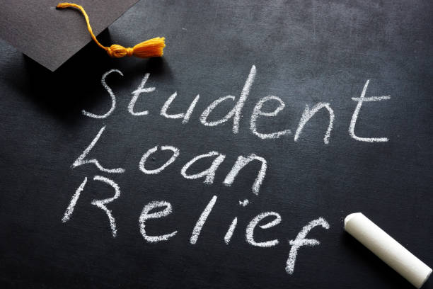 студенческий кредит помощи написано на доске и выпускной крышкой. - student loans стоковые фото и изображения