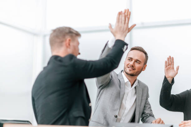 istock young employees giving each other a high five 1298629344