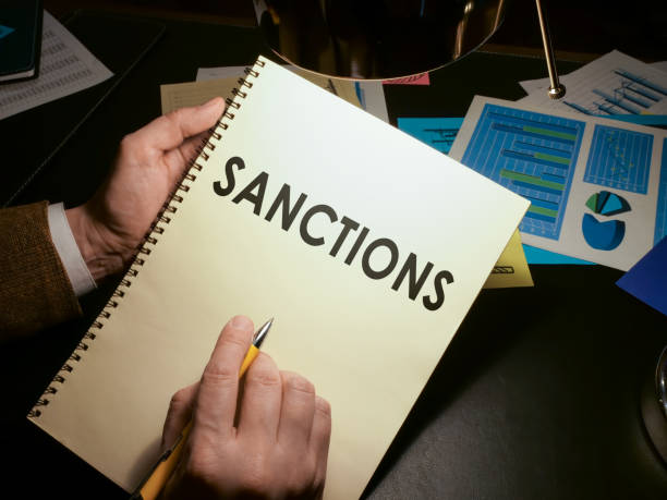 istock Hands hold a list of economic sanctions. 1298629547