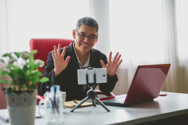 istock Mature business man having a video chat in his office using his mobile phone 1298630664