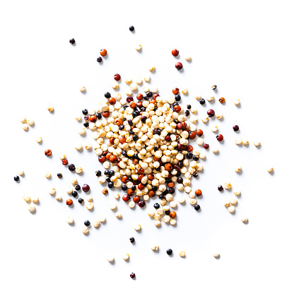 Overhead view of a mix of black, red and white quinoa seeds heap spilled on white background. High resolution 42Mp studio digital capture taken with Sony A7rII and Sony FE 90mm f2.8 macro G OSS lens