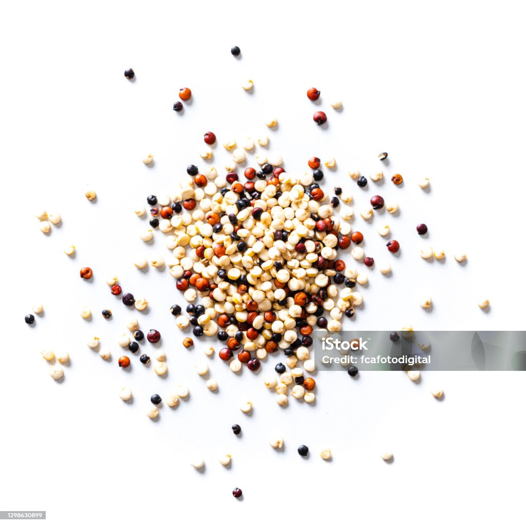 Mix of black, red and white quinoa seeds spilled on white background. Overhead view Overhead view of a mix of black, red and white quinoa seeds heap spilled on white background. High resolution 42Mp studio digital capture taken with Sony A7rII and Sony FE 90mm f2.8 macro G OSS lens Quinoa Stock Photo