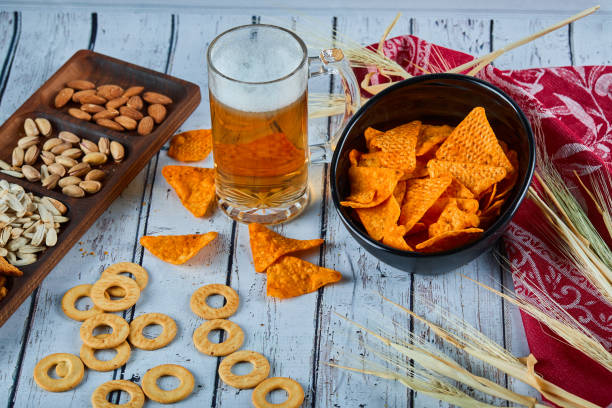 istock Assorted snacks, chips, and a glass of beer on blue table 1298631429