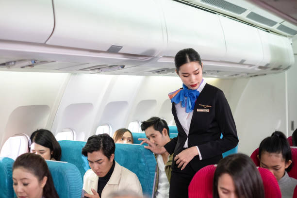 istock Stewardess in uniform looking all passengers to fasten seat belt while sitting on the airplane for safety flight. The security system is rigorous. International Airlines. Long trip for vacation 1298634400
