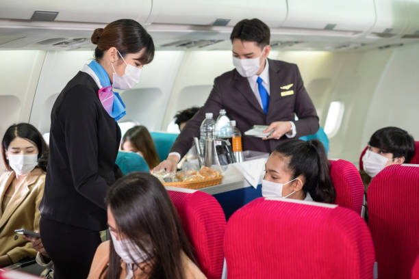 Flight attendants or stewardess are moving trolley and serving light snack, water and tea of coffee to passengers in the flight in economy class. Travel and relaxation concept. Flight attendants or stewardess are moving trolley and serving light snack, water and tea of coffee to passengers in the flight in economy class. Travel and relaxation concept. airplane food stock pictures, royalty-free photos & images