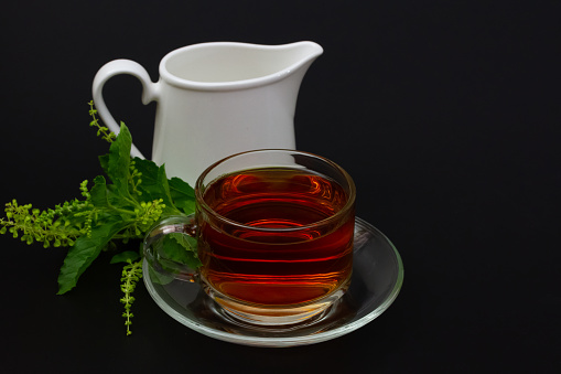 Black tea with camomile on white background. Isolated