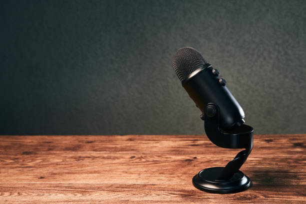 istock microphone on a wooden table on gray background 1298641468