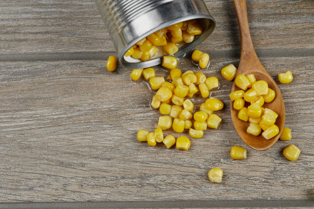 istock A can of boiled sweet corn on a wooden table with a spoon 1298641833