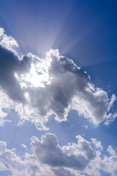 istock Blue sky and white cumulus clouds, clouds obscure the sun, sunlight can be seen from behind the clouds. 1298644272