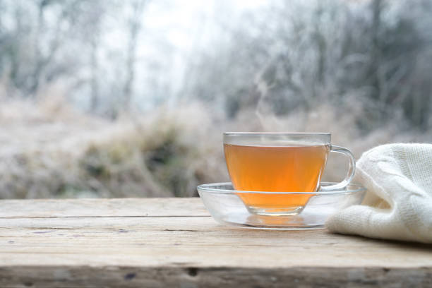istock Hot tea on a rustic wooden table outdoors on a cold winter morning, copy space 1298644616