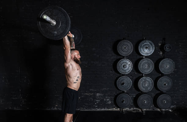 istock Young active strong fit muscular sweaty man with big muscles doing barbell weight lifting cross training workout in the gym dark image real people 1298645939