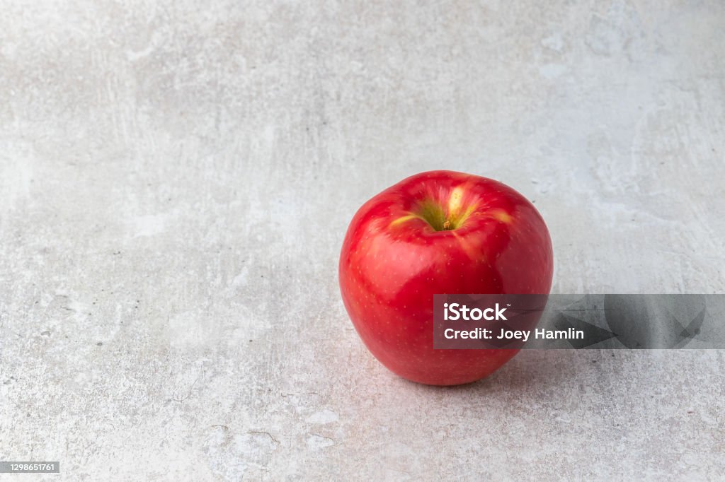 Red apple on a light background Red apple isolated on a simple light colored background Agriculture Stock Photo