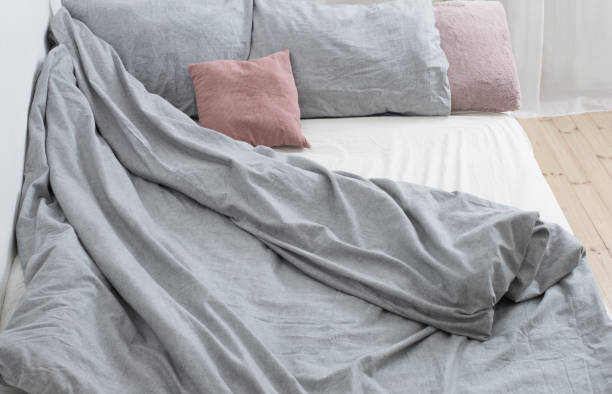 istock bed with gray linens in  white interior 1298652477
