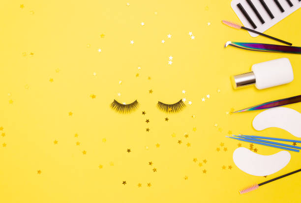 istock Eyelash extension tools and artificial eyelashes on a yellow background. The view from the top. 1298656307