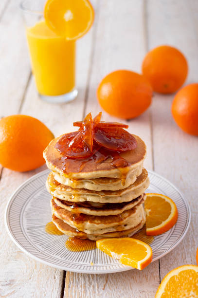 istock Pancake tower with orange marmalade, fresh oranges and juice for breakfast on rustic wooden table 1298657197