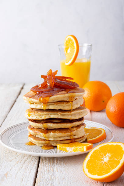 istock Pancake tower with orange marmalade, fresh oranges and juice for breakfast on rustic wooden table 1298657200