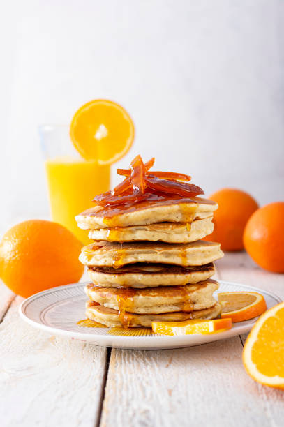 istock Pancake tower with orange marmalade, fresh oranges and juice for breakfast on rustic wooden table 1298657204