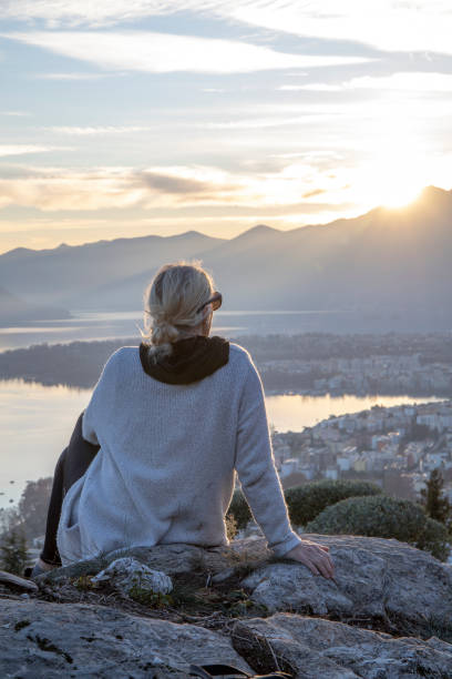 istock Female hiker relaxes on mountain ridge at sunrise 1298658770