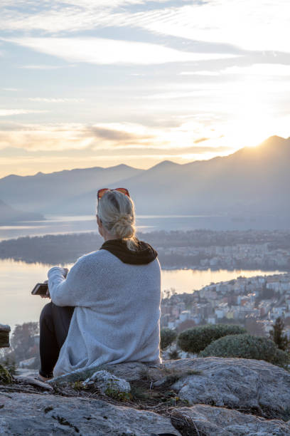 istock Female hiker relaxes on mountain ridge at sunrise 1298659350
