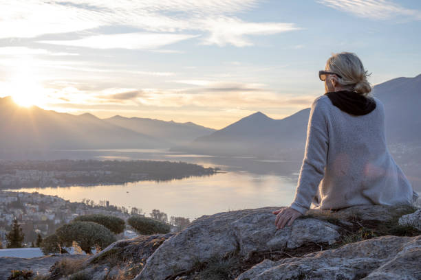 Female hiker relaxes on mountain ridge at sunrise