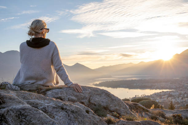 istock Female hiker relaxes on mountain ridge at sunrise 1298659627