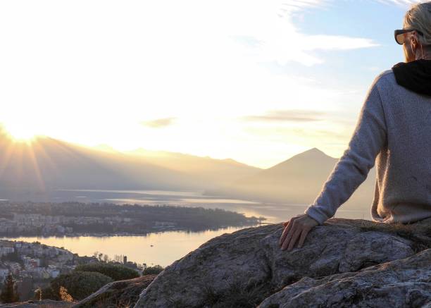 istock Female hiker relaxes on mountain ridge at sunrise 1298659829