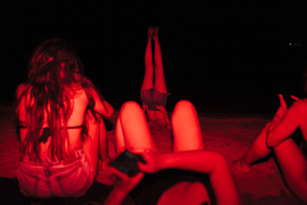 gruppo di giovani donne che si divertono a una festa sul lago di notte con una luce rossa - spanish culture flash foto e immagini stock