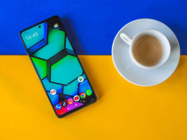 xiaomi poco x3 nuevo teléfono inteligente azul con café de cerca, y fondo amarillo y azul, desarrollado por xiaomi inc. xiaomi es una compañía de electrónica china de propiedad privada. - tiktok fotografías e imágenes de stock