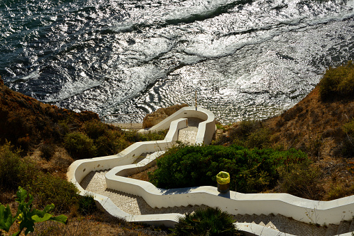 Carvoeiro, Lagoa, Algarve / Faro District, Portugal: winding stairs leading down to Paraiso beach - a path with hundreds of steps arranged in switchbacks allows access to Praia do Paraíso - looking down at the waves of the Atlantic Ocean.