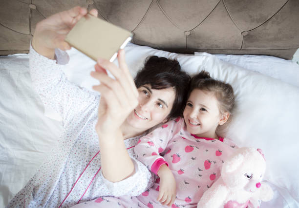 istock Young family taking selfie with smartphone in bed 1298669692