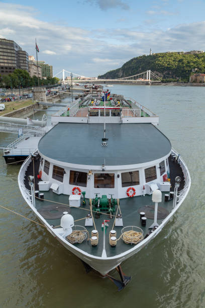Budapest, Hungary - July 17, 2012: A huge ship, type ferry, docked on the wide Danube river, passing through Budapest, with the Elisabeth Bridge in the background, on the Pest side, Budapest.