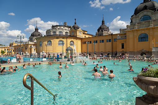 Budapest, hungary - July 18, 2012: Main outdoor pools of the famous Széchenyi Spa in Budapest, full of people bathing and enjoying a relaxing day in its warm waters.