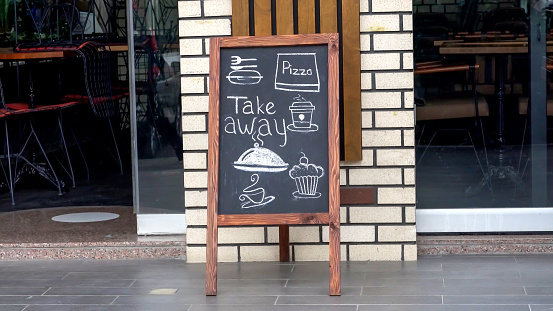 A blackboard stands in front of a cafe
