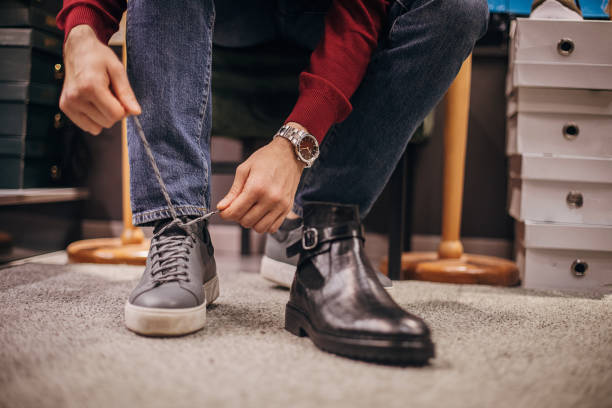istock Man trying on new shoes in shoe store 1298672006