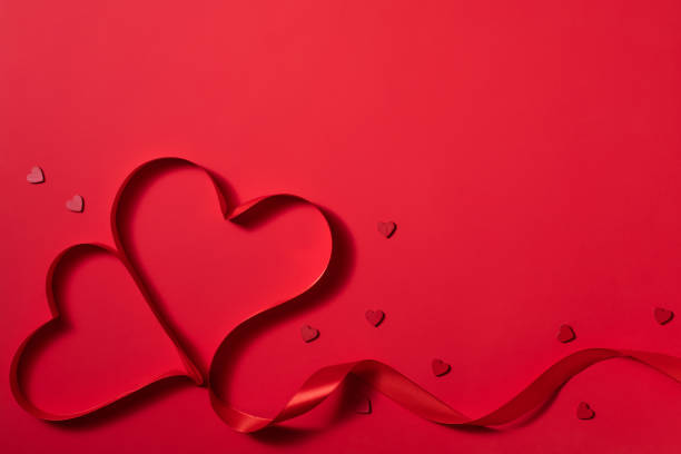 istock Valentine's day background with heart shape decorations and ribbons. View from above. Flat lay composition on red 1298672191