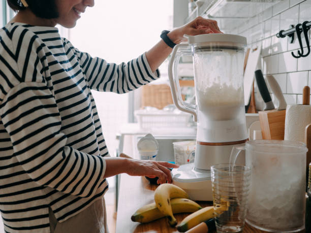istock Asian woman making smoothie. 1298672263
