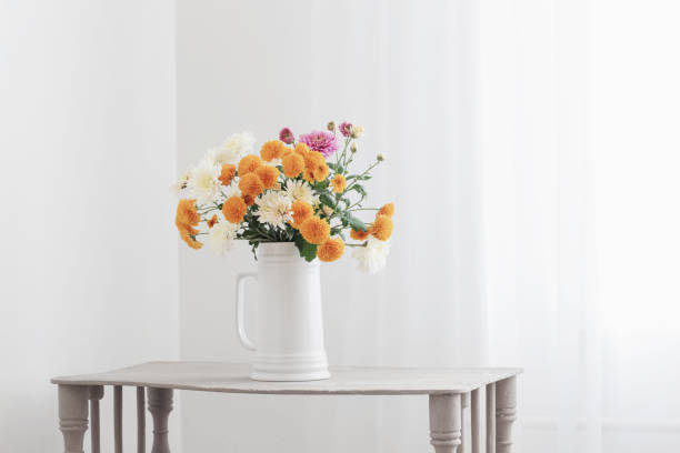 istock chrysanthemum flowers in white jug in white interior 1298675878